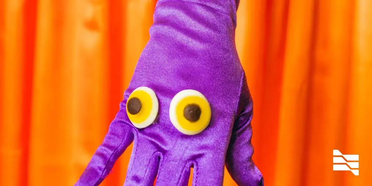 Vibrant purple hand puppet against an orange backdrop, from '5 Marketing Tips for Freelancers During the Pandemic'.