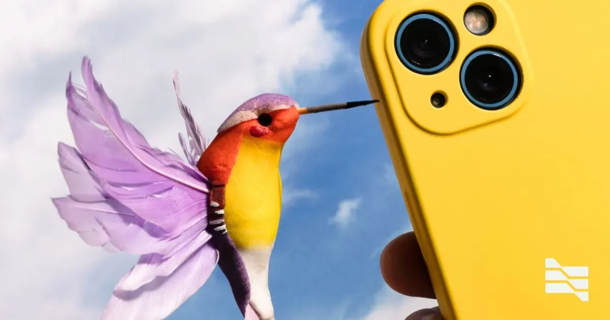 Colorful hummingbird approaching a yellow smartphone camera, evoking the ease of accessing online learning platforms.