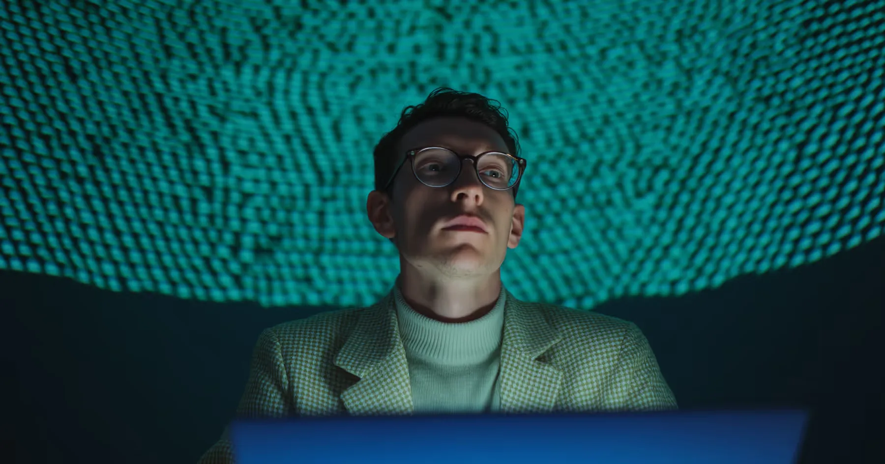 A man working on a laptop under green dome lighting
