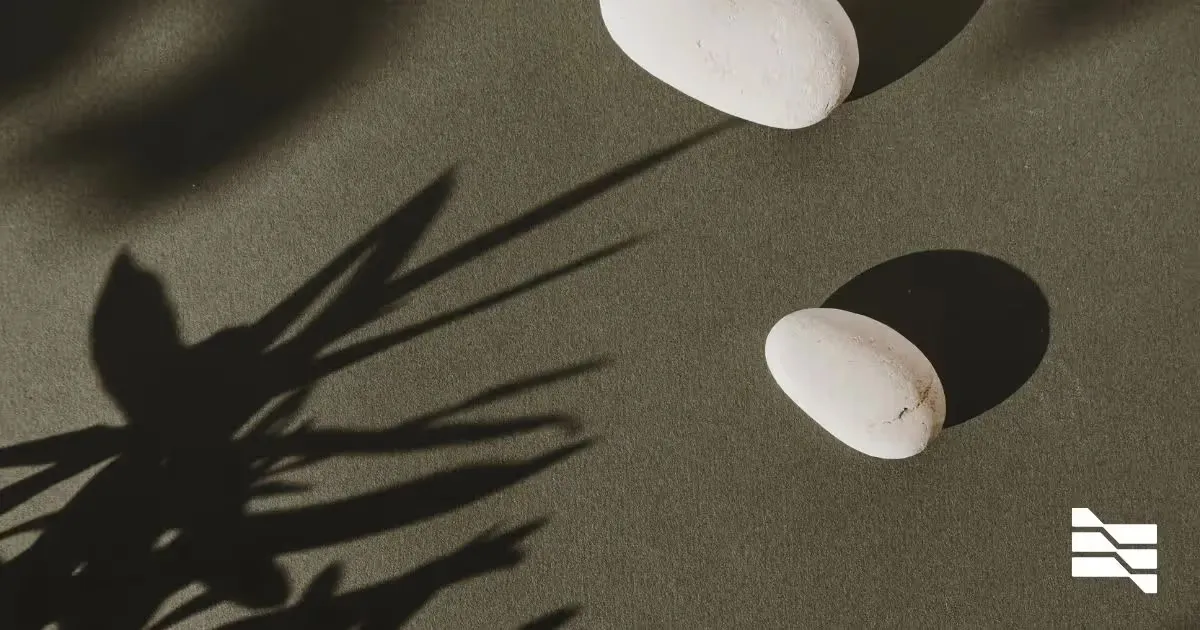 Zen-like arrangement of stones and shadows, representing the balance between freelance and full-time work.