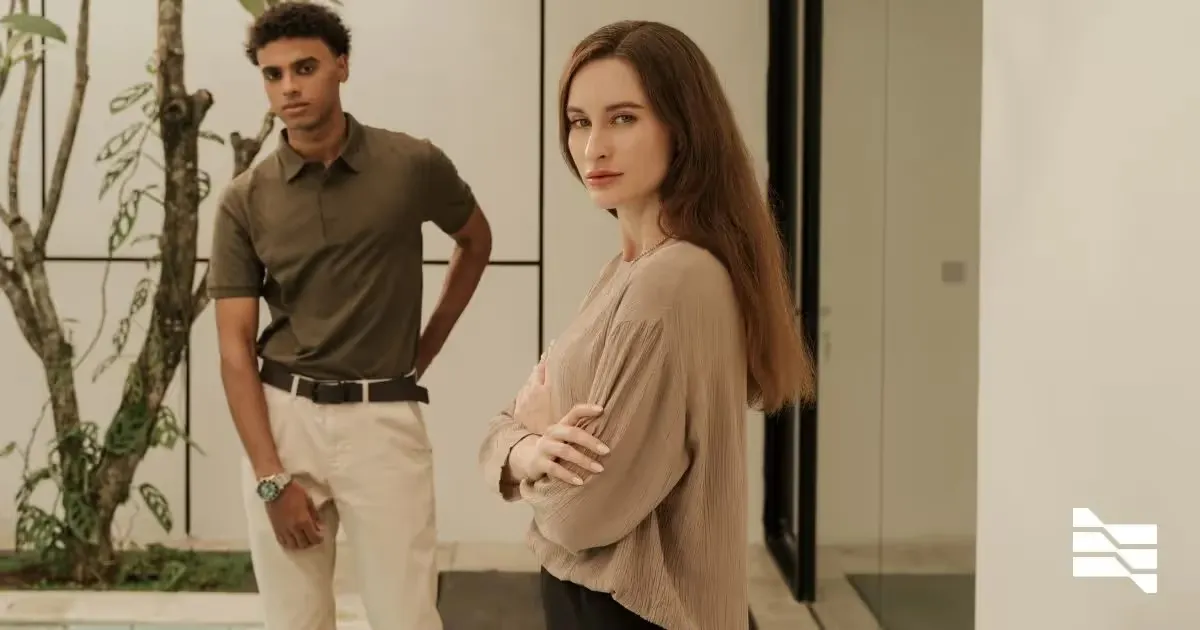 Confident woman in the foreground with a man standing behind, symbolizing the dynamics of onboarding freelancers compliantly.