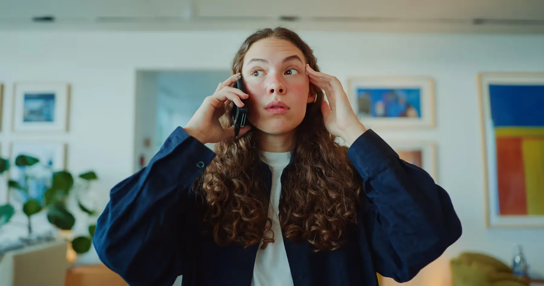 A woman talking on the phone with a surprised expression